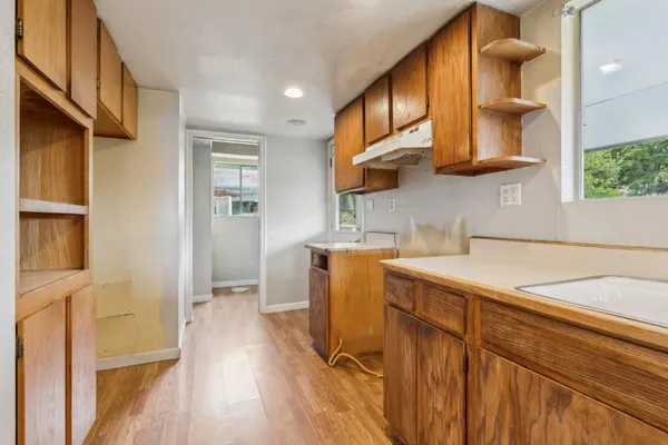 a kitchen with a sink cabinets and wooden floor