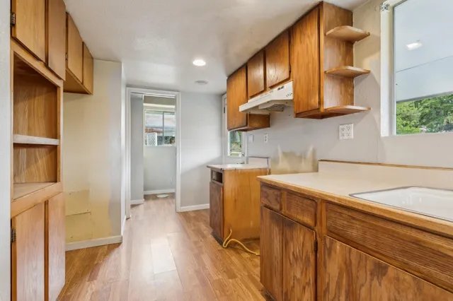 a kitchen with a sink cabinets and wooden floor