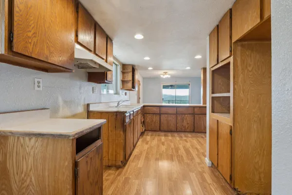 a kitchen with a sink a counter top space stainless steel appliances and cabinets