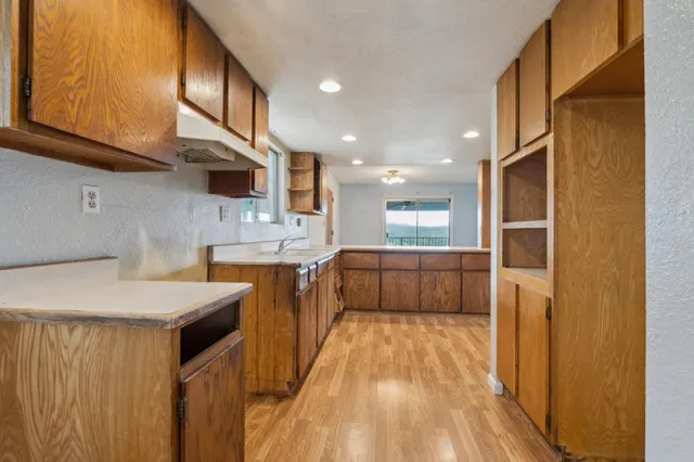 a kitchen with a sink a counter top space stainless steel appliances and cabinets