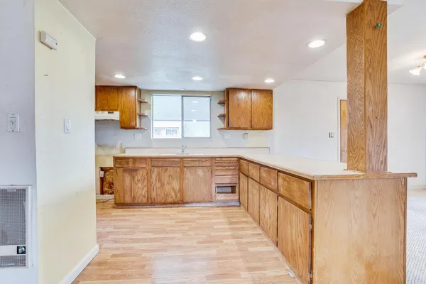 a large kitchen with stainless steel appliances granite countertop a large counter top a stove a sink and a refrigerator