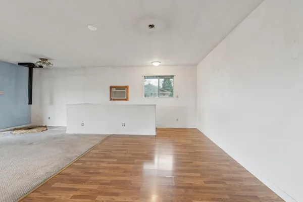 a view of a room with wooden floor and a ceiling fan