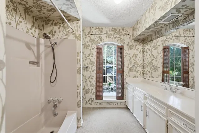 a bathroom with a granite countertop sink a toilet and shower