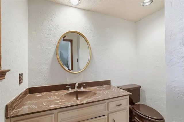 a bathroom with a granite countertop sink a mirror and vanity