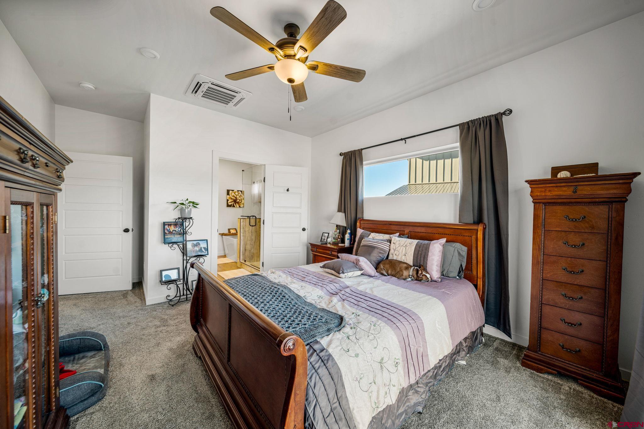 215 West Menefee Street Mancos, CO 81328 - Photo 15 of 29 a bed room with a bed and a chandelier