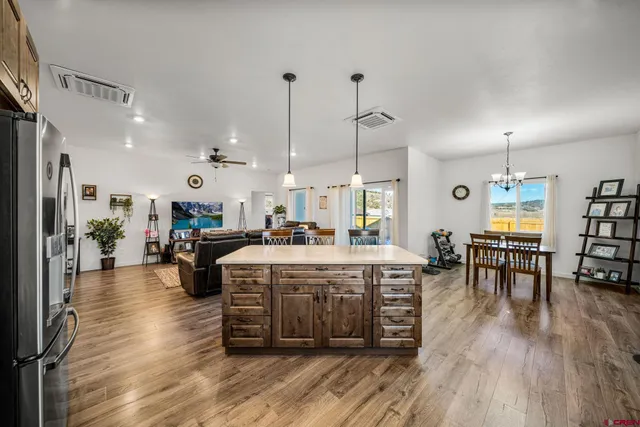 a large kitchen with lots of counter space a sink and chairs