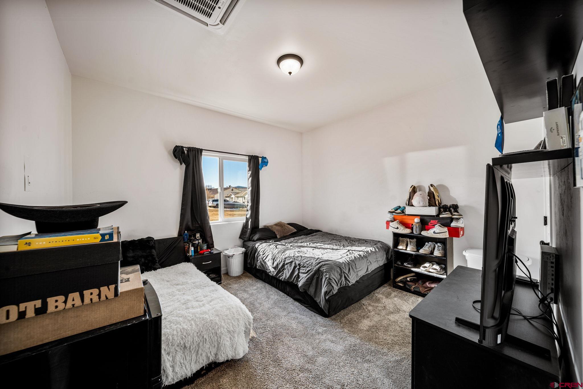 215 West Menefee Street Mancos, CO 81328 - Photo 27 of 29 a bedroom with two bed and a window