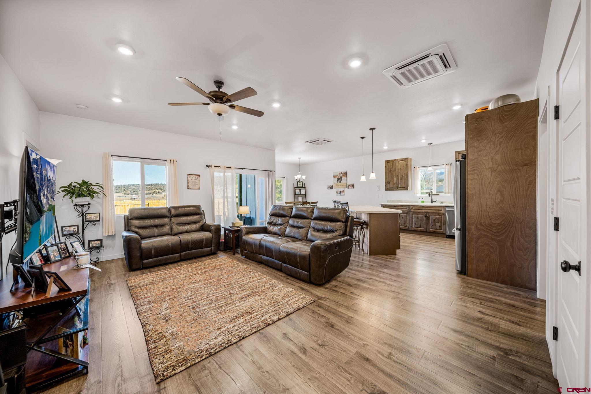 215 West Menefee Street Mancos, CO 81328 - Photo 6 of 29 a living room with furniture flat screen tv and a refrigerator