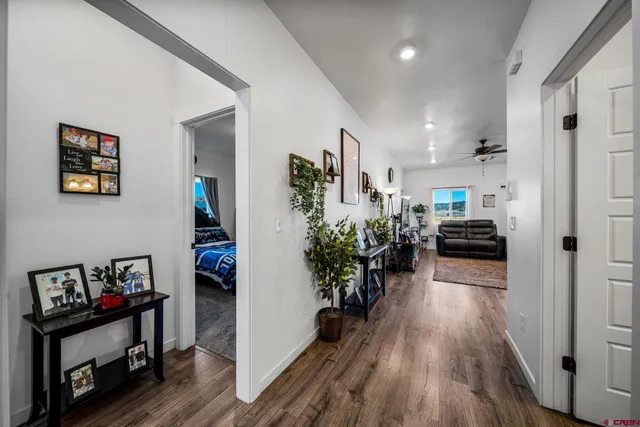 a view of a hallway with wooden floor and a living room