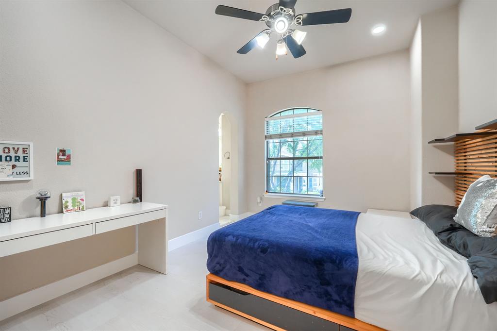 2246 Longview Road Irving, TX 75063 - Photo 33 of 40 Bedroom featuring a vaulted ceiling with a ceiling fan, an arched window, and a built-in desk with drawers