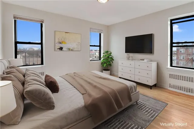 a view of an empty room with window and wooden floor