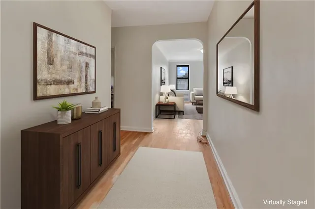 a hallway with painting on the wall and a baby crib