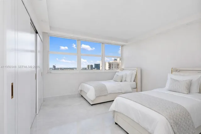 a bedroom with two beds and a large window