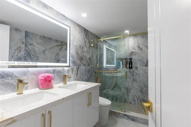 a bathroom with a sink vanity mirror and toilet