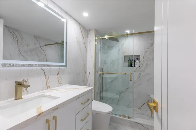 a bathroom with a granite countertop sink toilet and shower