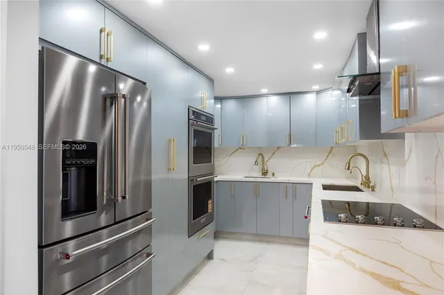 a kitchen with stainless steel appliances kitchen island granite countertop a refrigerator and a sink