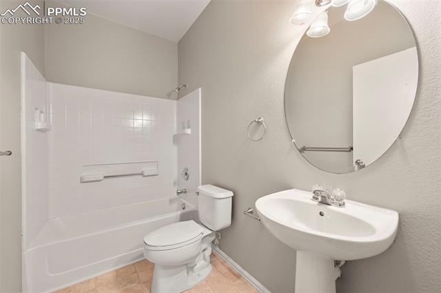 11927 Rodez Grove Peyton, CO 80831 - Photo 22 of 34 Bathroom with bathing tub / shower combination, tile patterned flooring, toilet, and baseboards
