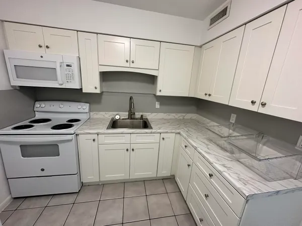 a kitchen with granite countertop cabinets and white appliances