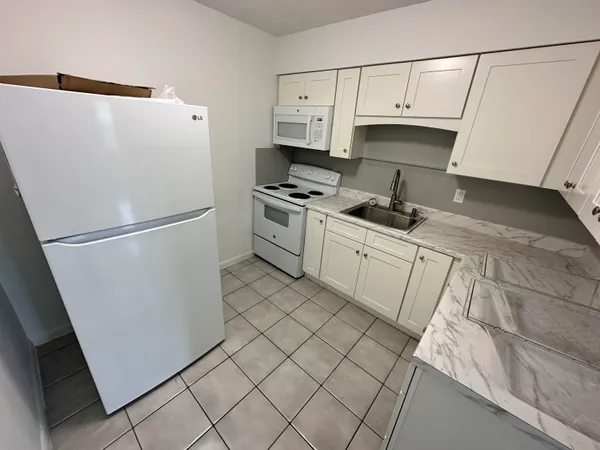 a kitchen with stainless steel appliances a refrigerator sink and cabinets