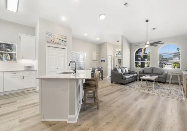 a open kitchen with stainless steel appliances granite countertop a stove and a sink with chair