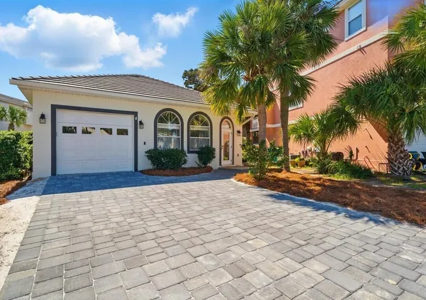 a front view of a house with a yard and potted plants