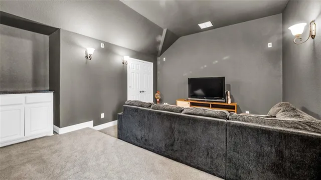 a living room with a flat screen tv and a refrigerator