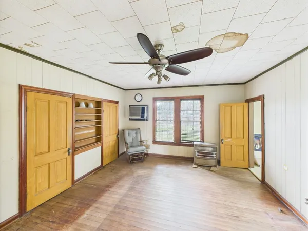 a bedroom with furniture and a large window