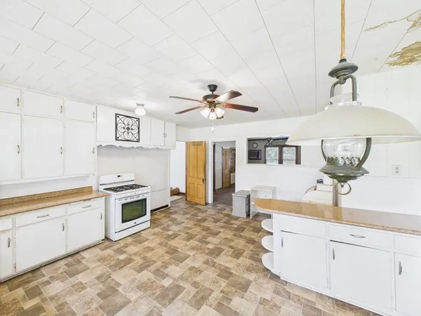 a kitchen with stainless steel appliances granite countertop a stove cabinets and window