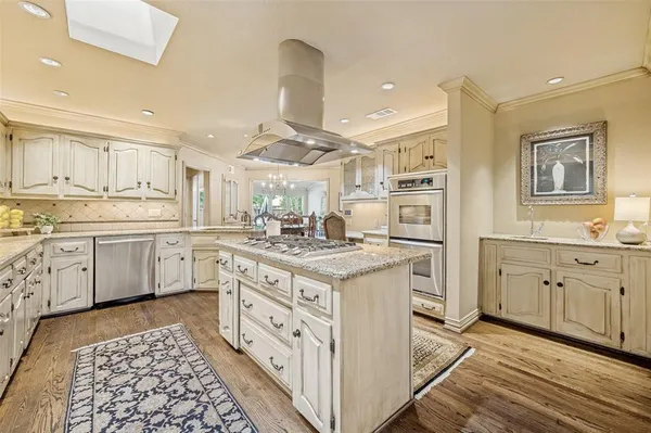 a kitchen with granite countertop a sink stove cabinets and wooden floor