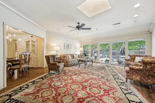 a living room with lots of furniture wooden floor and a large window