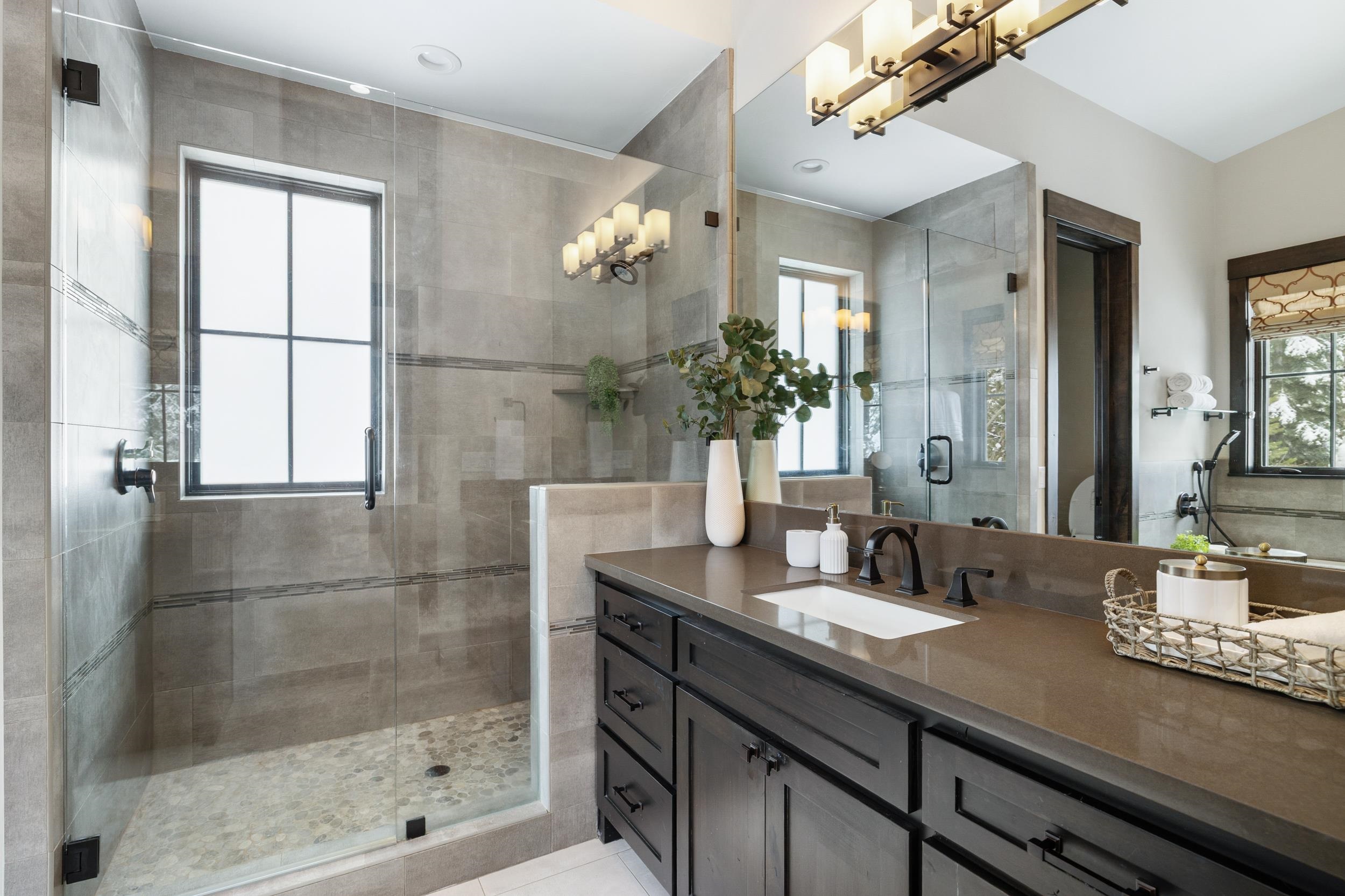 10601 Carson Range Road Truckee, CA 96161 - Photo 23 of 28 a bathroom with a granite countertop sink a mirror and a shower