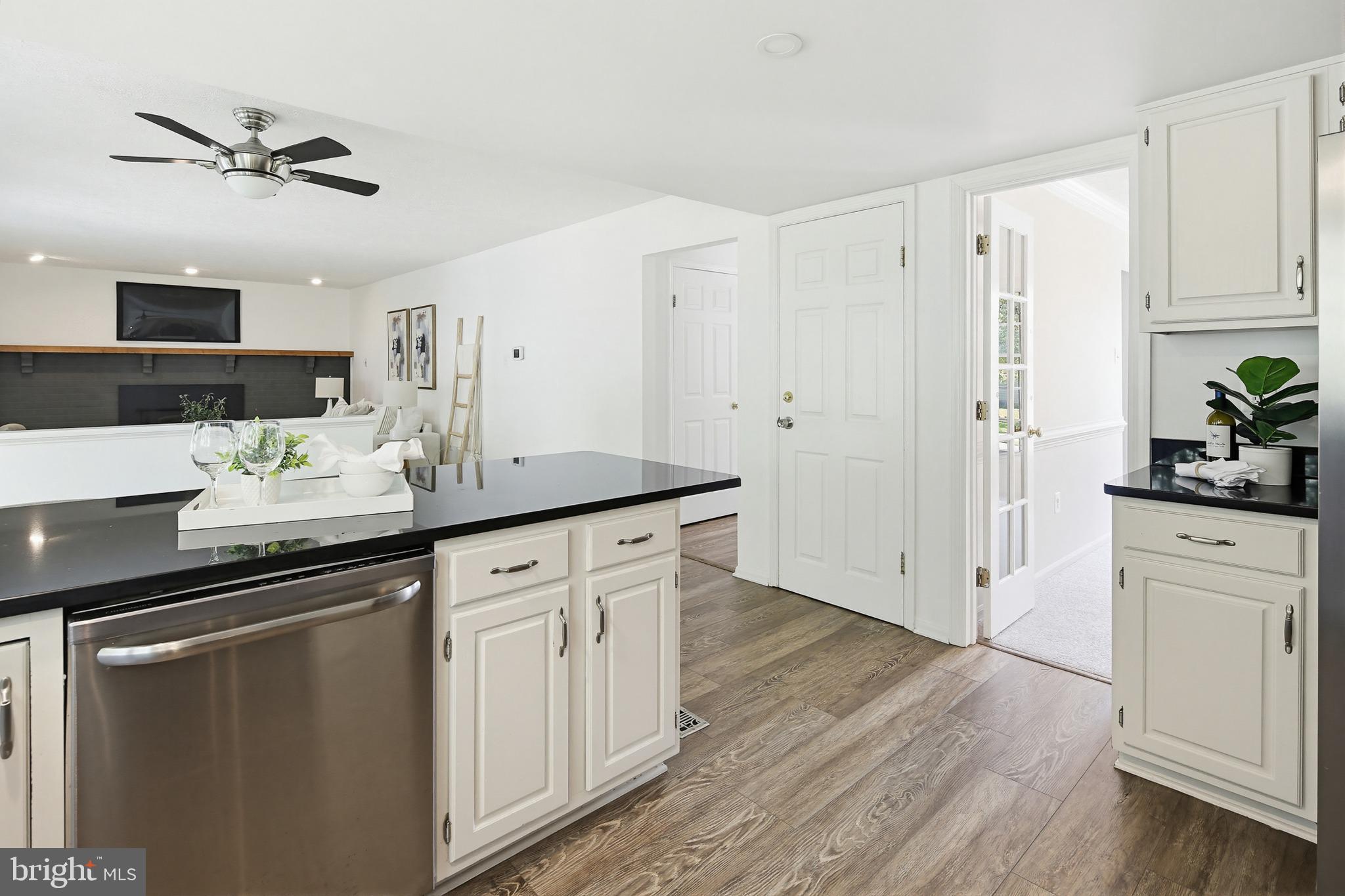 4608 Old Dragon Path Ellicott City, MD 21042 - Photo 13 of 60 a kitchen with white cabinets and black appliances