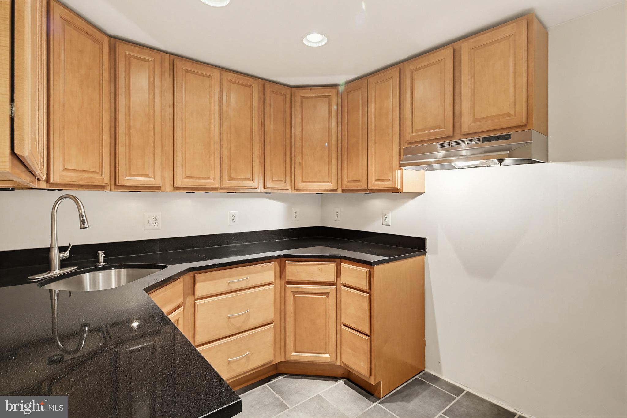 4608 Old Dragon Path Ellicott City, MD 21042 - Photo 52 of 60 a kitchen with stainless steel appliances granite countertop a sink a stove and white cabinets