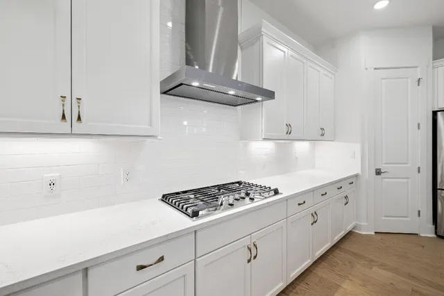 a kitchen with white cabinets and appliances