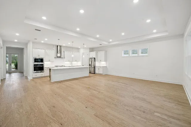 a view of kitchen with kitchen island a sink stainless steel appliances and white cabinets