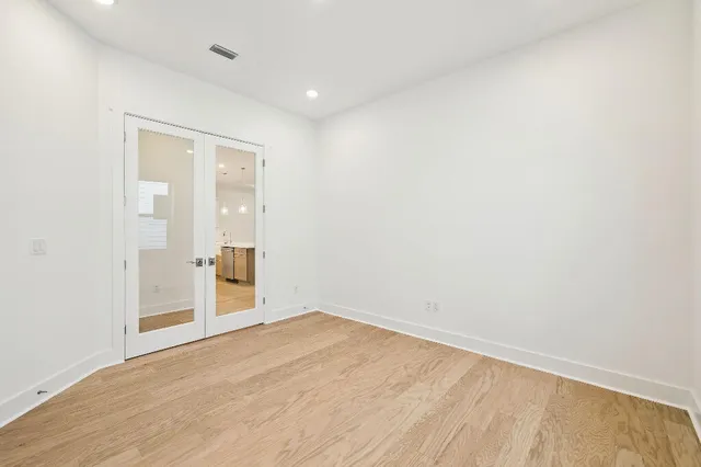 an empty room with wooden floor and door