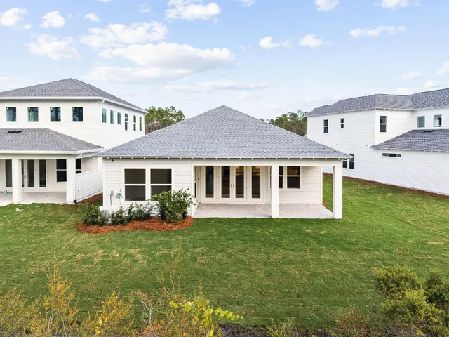 a front view of a house with a garden and trees