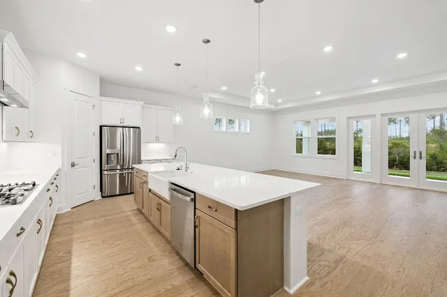 a large kitchen with stainless steel appliances kitchen island a large counter top and a refrigerator