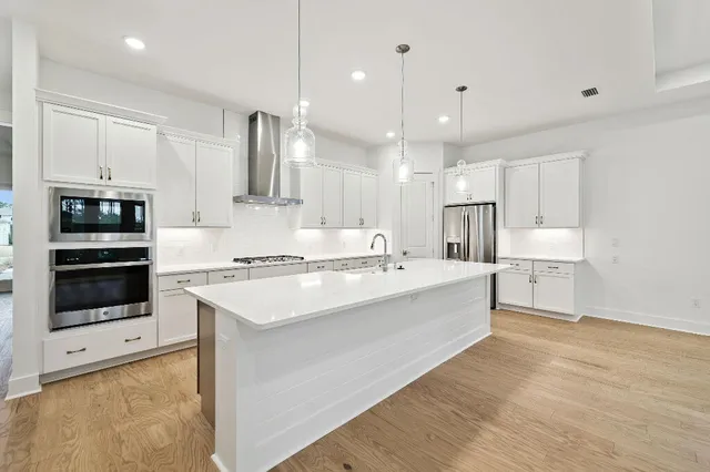 a large kitchen with kitchen island a sink stainless steel appliances and cabinets