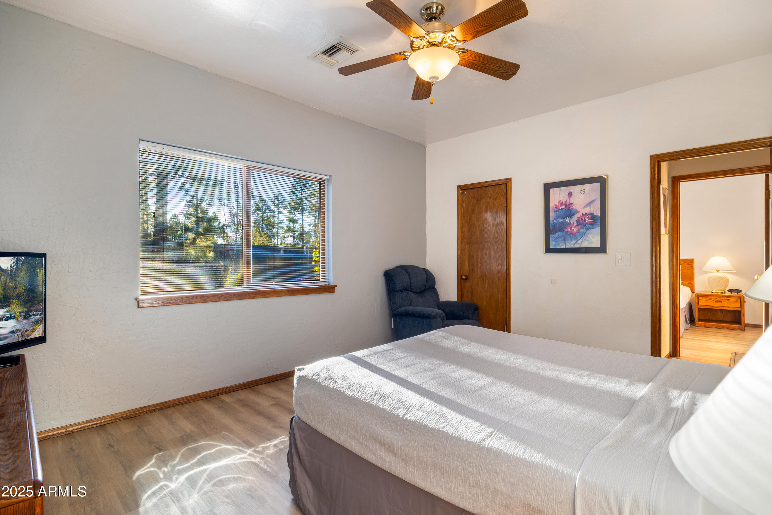 5829 East Buck Springs Road, Unit 255 Pinetop, AZ 85935 - Photo 9 of 21 a bedroom with a large bed and a chandelier