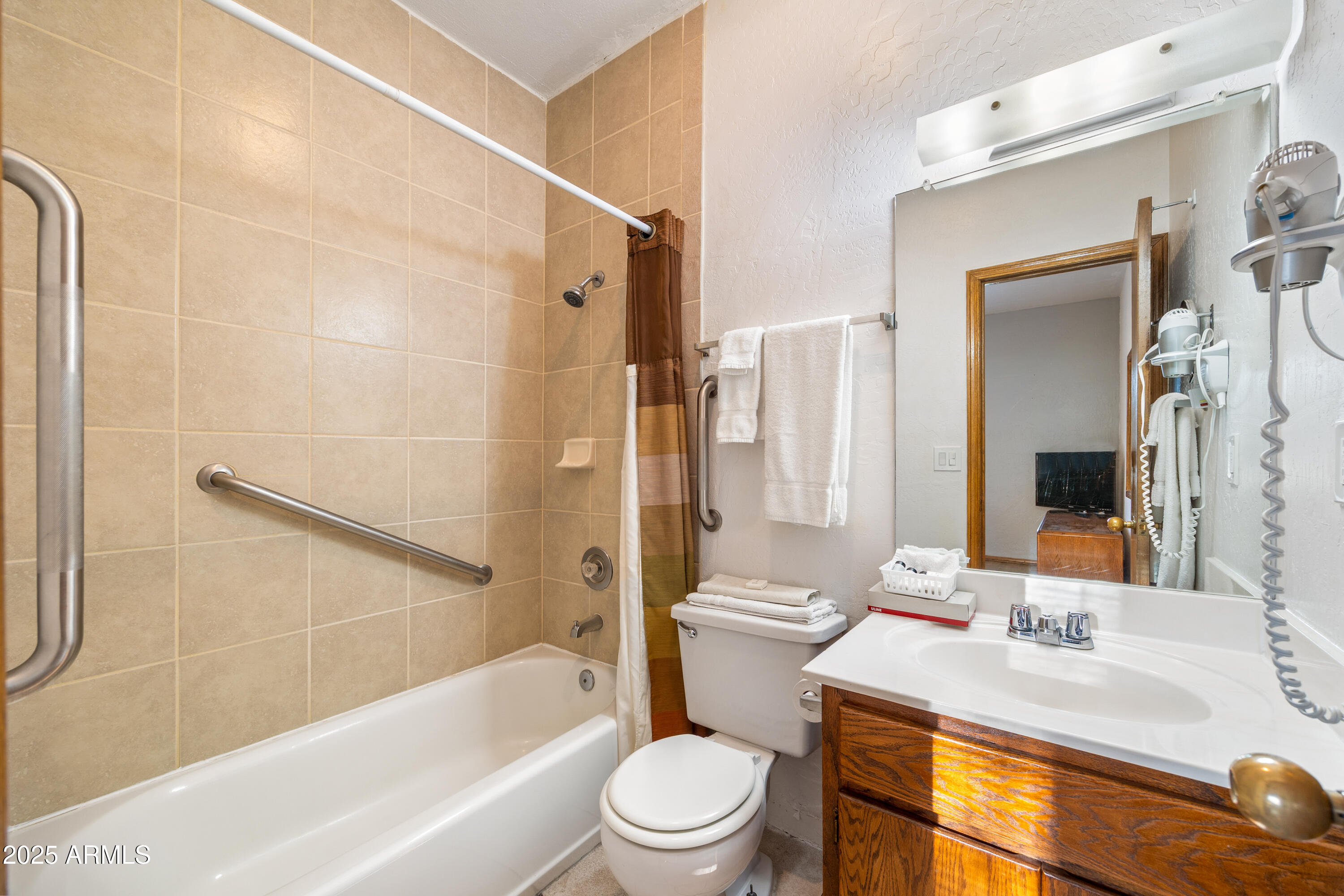 5829 East Buck Springs Road, Unit 255 Pinetop, AZ 85935 - Photo 10 of 21 a bathroom with a sink a toilet a mirror a bathtub and shower