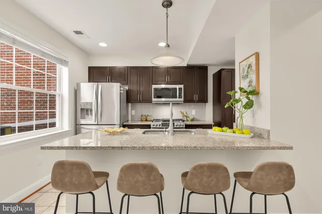 a kitchen with kitchen island granite countertop a counter top space appliances and a dining table
