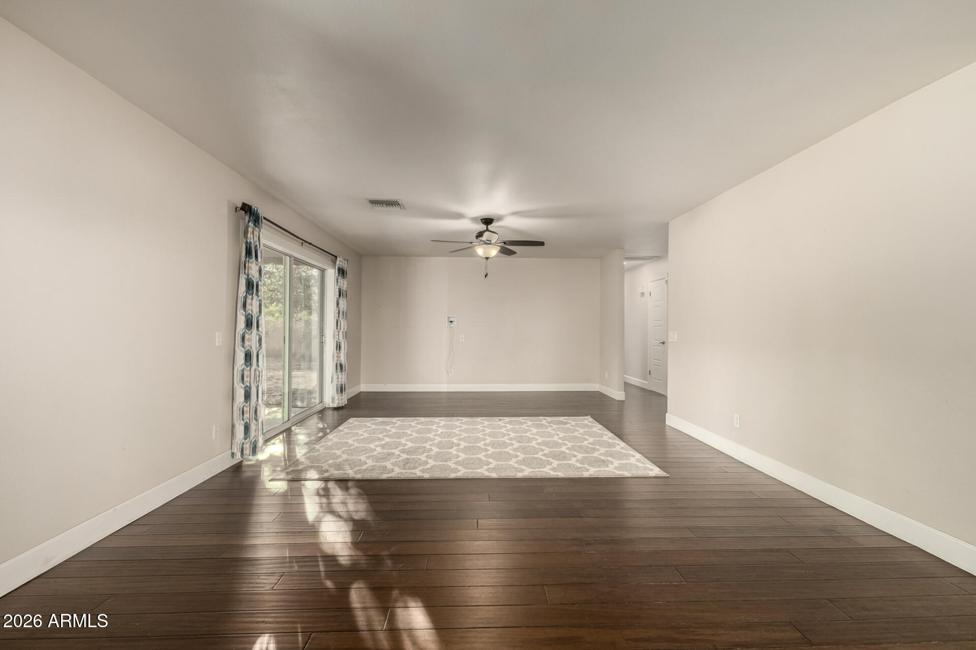 1649 West Royal Palm Road Phoenix, AZ 85021 - Photo 13 of 32 an empty room with wooden floor ceiling fan and windows