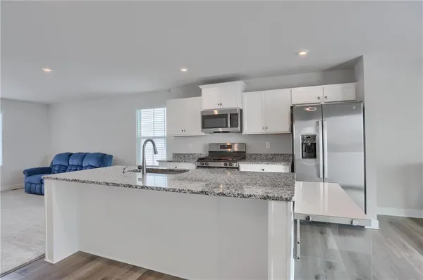 a kitchen with appliances a sink and cabinets