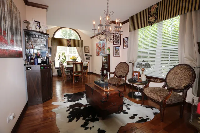 a living room with furniture chandelier and a large window