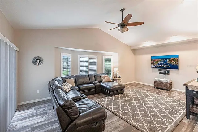 a bedroom with a large bed and a chandelier fan