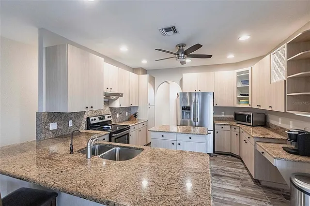a kitchen with a refrigerator stove and cabinets
