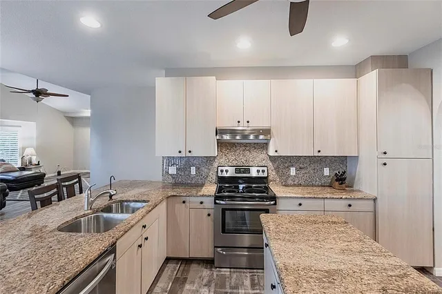 a kitchen with granite countertop a stove sink and cabinets