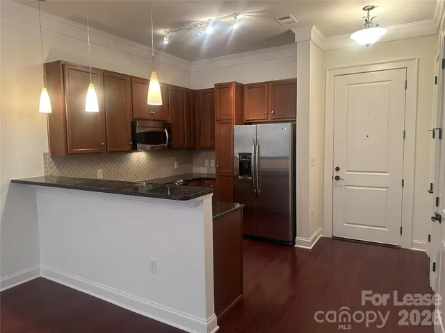 a modern kitchen with stainless steel appliances granite countertop a refrigerator a sink and a stove