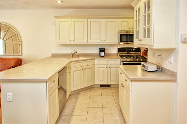 48 Turnberry Road, Unit 48 Bourne, MA 02532 - Photo 3 of 20 a kitchen with stainless steel appliances a stove a sink and white cabinets